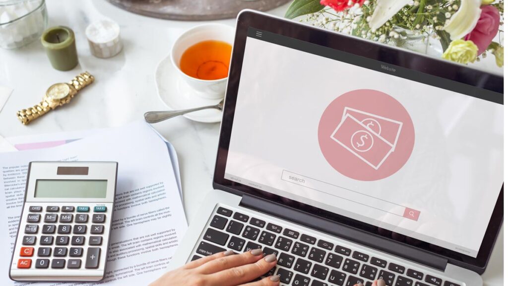 Donna al lavoro su laptop con calcolatrice e tè mentre calcola il costo di un sito WordPress nel 2025