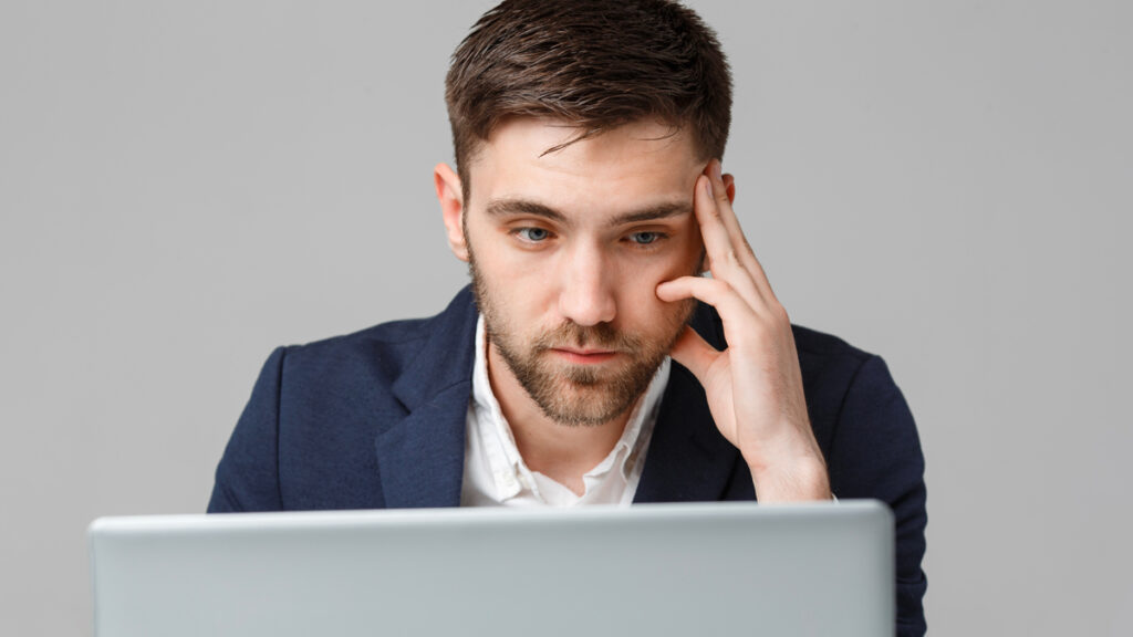 Professionista con espressione perplessa di fronte allo schermo del computer