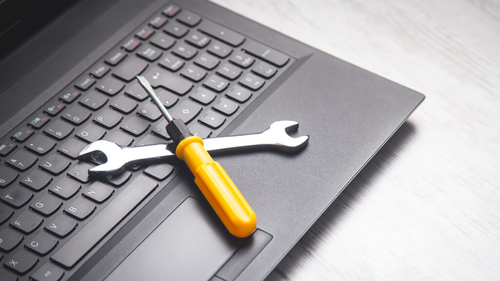Strumenti di manutenzione su un computer portatile, simbolo della manutenzione sito WordPress